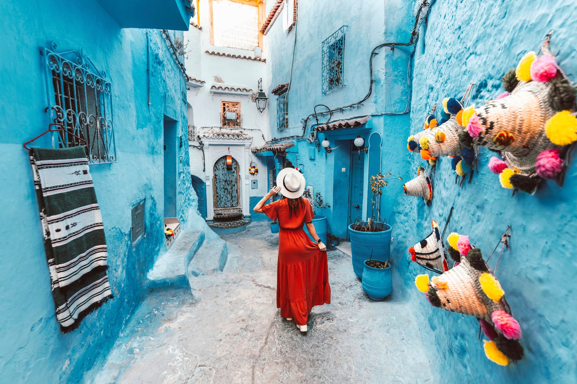 Woman in a red dress exploring Chefchaouen's blue medina